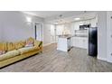 Open living space with modern kitchen and tile flooring next to a comfortable sofa at 6165 Carrier Dr # 1603, Orlando, FL 32819