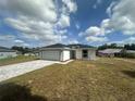 Beautiful single-story home showcasing a two-car garage and a lovely front lawn under a partly cloudy sky at 68 Water Track Loop, Ocala, FL 34472