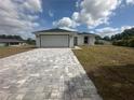 Inviting single-story residence featuring a two-car garage and a charming walkway, set against a blue sky backdrop at 68 Water Track Loop, Ocala, FL 34472