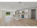 Bright, open kitchen featuring an island, modern appliances, white cabinets, and wood-look floors at 68 Water Track Loop, Ocala, FL 34472