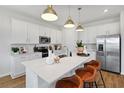 Bright kitchen featuring a large island with seating, stainless steel appliances, and stylish pendant lighting at 808 Lake Dell Rd, Dundee, FL 33838