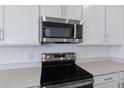 Close up of modern kitchen appliances including stainless steel microwave and electric range at 808 Lake Dell Rd, Dundee, FL 33838