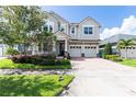 Beautiful two-story home featuring a brick-paved driveway, well-maintained lawn, and a three-car garage at 8228 Randal Park Blvd, Orlando, FL 32832
