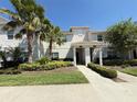 Charming townhome showcasing a well-maintained exterior with mature trees and lush landscaping at 9055 Dogleg Dr, Davenport, FL 33896