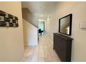 Bright hallway with tiled floors, leading to a dining area and staircase at 9055 Dogleg Dr, Davenport, FL 33896