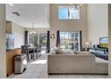 Open-concept living room with tile floors, high ceilings, and sliding glass doors to the outdoor pool area at 997 Lake Berkley Dr, Kissimmee, FL 34746