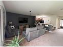 Open-concept living room with plush seating, neutral color palette, and seamless flow to the kitchen at 10116 Shadow Leaf Ct, Orlando, FL 32825