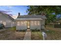 Charming single-story home with a metal roof, inviting front porch, and landscaped yard at 1018 Jersey Ave, St Cloud, FL 34769