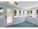Bright sun room with beadboard walls, aqua-blue floors, and multiple windows offering lots of natural light at 1018 Jersey Ave, St Cloud, FL 34769