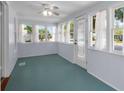 Bright sun room with beadboard walls, aqua-blue floors, and multiple windows offering lots of natural light at 1018 Jersey Ave, St Cloud, FL 34769