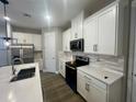 Beautiful kitchen with white cabinets, stainless steel appliances, sleek countertops, and modern tile backsplash at 12253 S Bracco St, Winter Garden, FL 34787