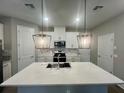 Modern kitchen featuring a large island, stainless steel appliances, stylish pendant lighting, and ample counter space at 12253 S Bracco St, Winter Garden, FL 34787