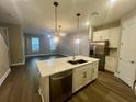 Open-concept kitchen and living area, featuring a large island, stainless steel appliances, and contemporary lighting at 12253 S Bracco St, Winter Garden, FL 34787