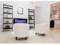Bright living area with tile floors, white walls, decorative shelving, and modern electric fireplace at 1302 Moss Creek Ln, Davenport, FL 33896