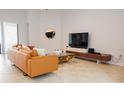 Bright living room with modern furniture, large-screen TV, and access to outdoor patio at 1302 Moss Creek Ln, Davenport, FL 33896