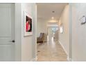 Long hallway with neutral colored walls and tile floors leading to the home's main living areas at 1443 Bunker Dr, Davenport, FL 33836
