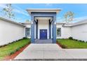 Inviting front entrance with blue pillars, a blue door, and well-maintained landscaping at 19182 Seaview St, Orlando, FL 32833