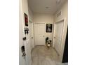 Hallway with multiple doors, neutral decor, and tiled floors at 209 Citrus Pointe Dr, Haines City, FL 33844