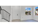 Bright entryway with white walls, modern windows, and stairs with a black iron railing at 227 Sand Ridge Drive, Davenport, FL 33896