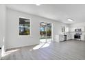 Open-concept kitchen featuring white cabinets, stainless steel appliances, and a sliding glass door to the outside at 227 Sand Ridge Drive, Davenport, FL 33896