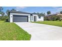 New home featuring a pristine driveway, attached garage and a well manicured lawn at 2437 Sw 147Th Ln, Ocala, FL 34473