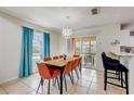 Open dining room with modern lighting and an adjacent screened patio view of the pool at 253 Granada Blvd, Davenport, FL 33837