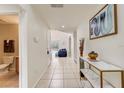 Inviting hallway with neutral tile flooring, console table and decor, leading to rooms filled with natural light at 253 Granada Blvd, Davenport, FL 33837