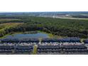 Aerial view of a townhouse community bordered by a lush nature preserve and pond at 2605 Reading Trl, Kissimmee, FL 34746