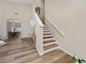 Inviting foyer with a staircase featuring wood and white risers and a light wood floor at 2764 Patrician Cir, Kissimmee, FL 34746