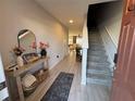 Inviting entryway with light wood floors, console table, and stairs to the upper level at 2883 Narcoossee Commons Way, St Cloud, FL 34771