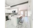 Bright kitchen features white cabinets, stainless steel appliances, and stylish marble floors at 3208 Timberline Road, Winter Haven, FL 33880