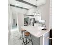 Bright kitchen features white cabinets, breakfast bar with bar stools, and stylish marble floors at 3208 Timberline Road, Winter Haven, FL 33880