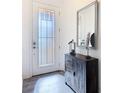 Bright entryway featuring a decorative cabinet, mirror, and stylish glass door at 343 Scripps Ranch Rd, Poinciana, FL 34759