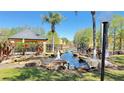 Scenic pond with a fountain, gazebo, rocks, palm trees, and well-maintained landscaping at 4528 Commander Dr # 2013, Orlando, FL 32822