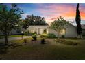 Beautifully landscaped single-story home with a well-maintained lawn under a picturesque sunset sky at 508 Alcazar Ct, The Villages, FL 32159