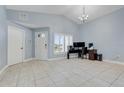 Open-concept living space featuring tile floors, high ceilings, and an office setup at 53 Zinnia E Ln, Kissimmee, FL 34759
