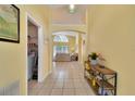 Welcoming hallway featuring tile flooring and an open view to the main living area and laundry at 577 Eagle Pointe S, Kissimmee, FL 34746