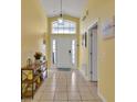 Bright entryway featuring tile flooring, transom window, and neutral yellow wall paint at 577 Eagle Pointe S, Kissimmee, FL 34746