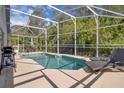 Inviting screened-in pool area with lounge chairs, a patio set, and a beautiful backyard view at 577 Eagle Pointe S, Kissimmee, FL 34746
