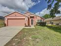Charming single-story home features a two-car garage and well-manicured lawn at 661 Sandy Ridge Dr, Davenport, FL 33896