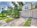 Charming townhome featuring a paved driveway, attached garage, manicured landscaping, and inviting curb appeal at 8374 Quimby Cir # 8374, Davenport, FL 33896