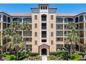 Multi-story condominium building featuring a tile roof and tropical landscaping at 8774 Worldquest Blvd # 7503, Orlando, FL 32821