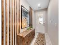 Bright foyer with decorative wooden wall accents, stylish furniture, and a view of the front door at 8943 Amelia Downs Trl, Kissimmee, FL 34747