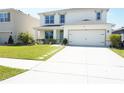 Charming two-story home featuring a well-manicured lawn and a convenient two-car garage at 9016 Pyrus St, Kissimmee, FL 34747