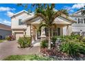 Charming two-story home featuring a covered porch with stone accents and beautifully landscaped front yard at 9056 Pinch Shot Dr, Winter Garden, FL 34787