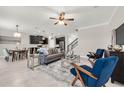 Open-concept living room and kitchen area featuring modern decor, sleek furniture, and a view of the staircase at 9056 Pinch Shot Dr, Winter Garden, FL 34787