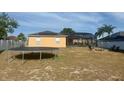 Expansive backyard featuring a trampoline, screened lanai and a cozy fire pit area at 1102 Peregrine St, Groveland, FL 34736