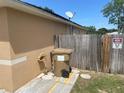Exterior side view of home featuring a fence, trash container, and a satellite dish at 1102 Peregrine St, Groveland, FL 34736
