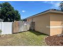 Side yard featuring a wooden fence, grass, and trees at 1102 Peregrine St, Groveland, FL 34736