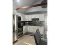 Modern kitchen boasting white cabinetry, stainless steel appliances, and granite countertops at 130 Avenue H Se, Winter Haven, FL 33880